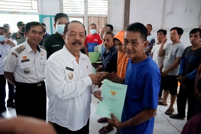 SERTIFIKAT : Wabup Sanggau saat menyerahkan sertifikat tanah milik warga di Desa Mengkiang, Kecamatan Kapuas. YOSAFAT/DISKOMINFO