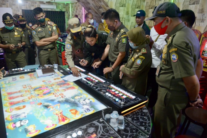 PENYEGELAN: Tim gabungan yang terdiri dari satuan polisi pamong praja, TNI dan Polri melakukan penyegelan arena permainan ketangkasan di sebuah rumah toko (ruko) di Jalan Siam, Kota Pontianak, Senin (4/7) sore. (ARIEF NUGROHO/PONTIANAK POST)