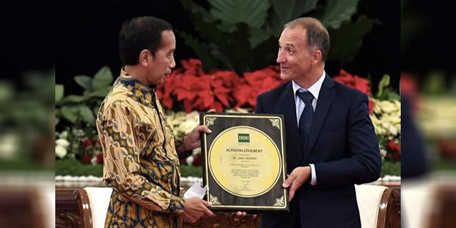 Direktur Jenderal IRRI Jean Balie menyerahkan penghargaan IRRI kepada Presiden Joko Widodo di Istana Negara, Jakarta, Minggu (14/8). Foto: Setpres