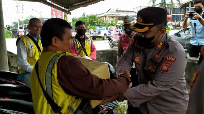 Kapolres Landak AKBP Stevy Frits Pattiasina memberikan bantuan Sosial kepada warga untuk meringankan beban warga yang terdampak kenaikan harga BBM pada Jumat (9/9). (Miftahul Khair/Pontianakpost)