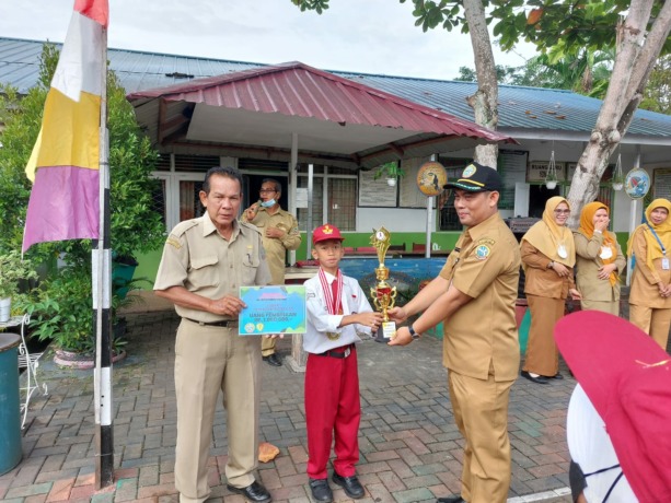 HADIAH: Kepala SD Negeri 06 Pontianak Timur, Ya’ Dedi Suhandi, didampingi Guru Olahraga menyerahkan hadiah kepada Zeedhan, Sabtu (3/9) kemarin.  (ist)