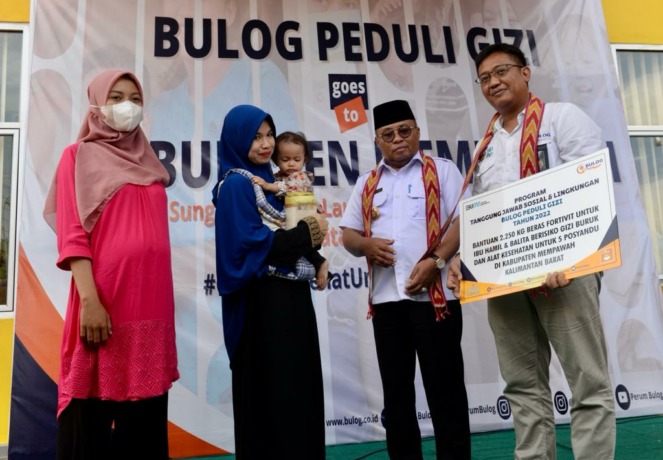 PENYERAHAN BANTUAN: Pemimpin Wilayah Bulog Kalimantan Barat, Bambang Prihatmoko menyerahkan bantuan Beras Fotivit kepada 50 ibu hamil dan 30 balita rawan gizi secara simbolis di kantor Desa Sungai Bundung Laut. Kecamatan Sungai Kunyit, Kabupaten Mempawah,