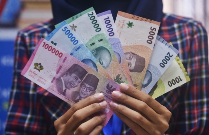 UANG BARU: Salah seorang warga memperlihatkan tujuh lembar pecahan Uang Rupiah Kertas Tahun Emisi 2022 miliknya, terdiri dari pecahan Rp100 ribu, Rp50 ribu, Rp20 ribu, Rp10 ribu, Rp5 ribu, Rp2 ribu, dan Rp1 ribu. MEIDY KHADAFI/PONTIANAK POST