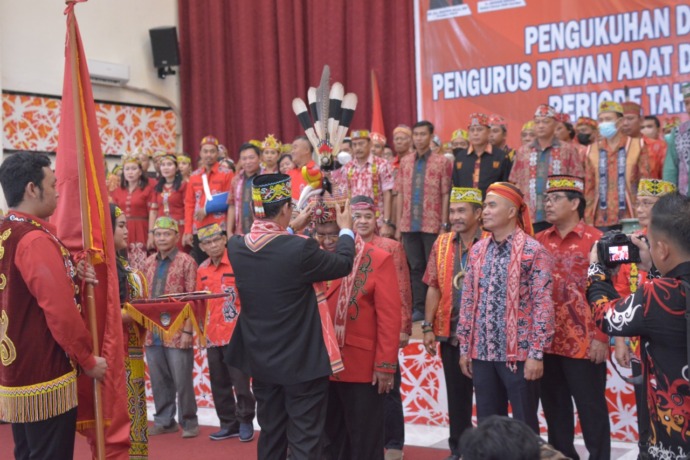 Ketua DAD Provinsi Kalbar menyerahkan penutup kepala kepada ketua DAD Landak Heri Saman, Senin (10/10). (Miftahul Khair/Pontianakpost)
