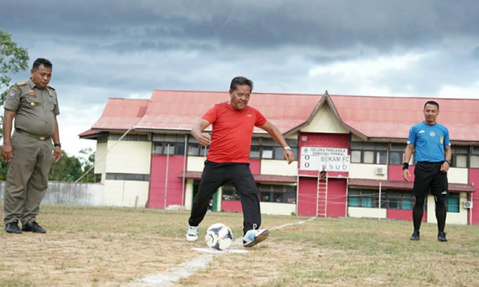 SERAHKAN : Bupati Sanggau menendang bola tanda kick off final liga ASN 2022, kemarin. SUGENG/PONTIANAK POST
