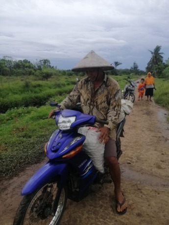 HASIL TANI: Transmigran terlihat membawa satu karung tomat hasil panen dari 1 hektar kebun tomat di Dusun Sidomulyo. IST