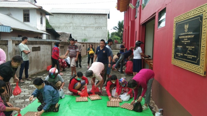 Yakob Pujana bersama anggota pemadam kebakaran swasta Sambas bagikan telur sumbangan dari Yayasan Pengurus Daerah Gema Budhi PRovinsi Kalbar di Pontianak. (IST)