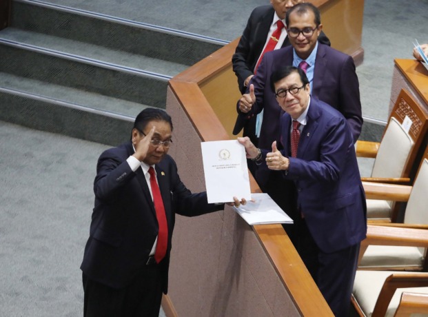 Menteri Hukum dan Hak Asasi Manusia Yasonna H Laoly (kedua kanan) dan Wakil Menteri Hukum dan HAM Edward Omar Sharif Hiariej (kanan) menerima dokumen laporan Komisi III terkait RKUHP dari Ketua Komisi III Bambang Wuryanto (kiri) saat Rapat Paripurna DPR k