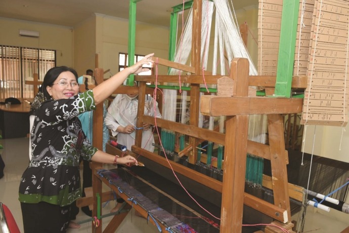 TENUN : Ketua Dekranasda Sanggau, Arita Apolina memperlihatkan alat tenun untuk menghasilkan kain tenun bermotif Sabang Merah. SUGENG/PONTIANAK POST