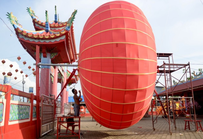HIAS LAMPION: Seorang pekerja menghias lampion raksasa di halaman Kelenteng Tri Dharma Hian Thian Shang Tie di Desa Sungai Kakap, Kecamatan Sungai Kakap, Kubu Raya, Kamis (12/1).  ARIEF NUGROHO/PONTIANAK POST