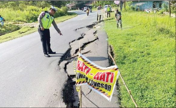 RETAK : Kondisi badan jalan nasional yang mengalami keretakan akibat longsor. FOTO: SUGENG / PONTIANAK POST