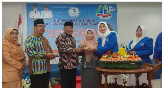 WAHYU/PONTIANAKPOST TUMPENG: Wabup Mempawah, Muhammad Pagi menerima potongan tumpeng dari Ketua IWAPI Mempawah.