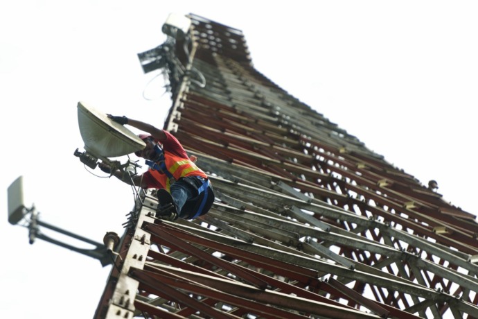 Teknisi sedang melakukan pemeliharaan transmisi di salah satu menara yang berlokasi di Jalan Lintas Malindo, Kecamatan Entikong, Kabupaten Sanggau, Provinsi Kalimantan Barat, Kamis (10/2). Jaringan XL Axiata di seluruh Kalimantan diperkuat oleh kabel fibe