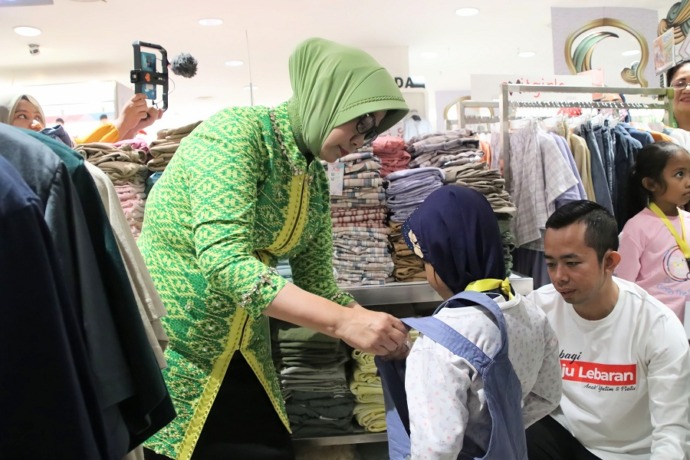 BAJU LEBARAN: Ketua TP-PKK Kalbar Lismaryani memasangkan pakaian baru untuk anak yatim piatu yang diajak berbelanja baju Lebaran di Ayani Mega Mal, Sabtu (1/4). BIRO ADPIM KALBAR FOR PONTIANAK POST