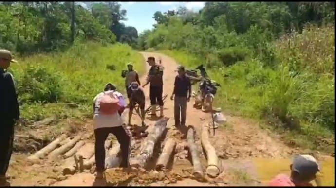BANGUN JEMBATAN: Warga Desa Kiung saat melakukan giat gotong royong membuat jembatan darurat menggunakan potongan kayu seadanya. IST