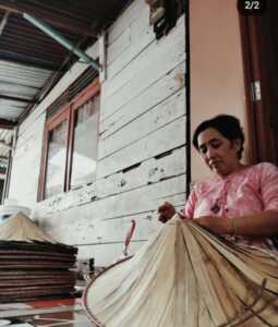 MEMBUAT CAPING: Seorang pengrajin sedang membuat topi caping.