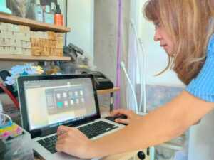 SIAPKAN POSTINGAN: Kristin Sisilia, pemilik usaha florist Surprise Me sedang mengedit foto yang akan diposting di Instagram.