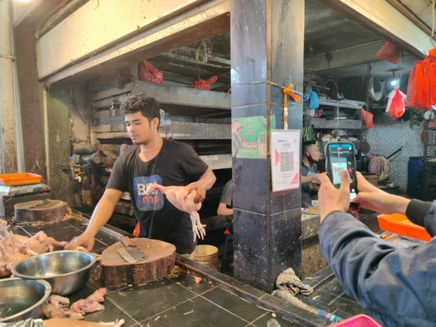 Pembeli sedang menggunakan pembayaran nontunai dengan QRIS di Pasar Flamboyan. (Syahriani Siregar/Pontianak Post)