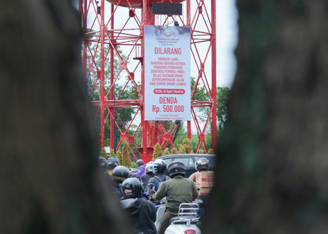 IMBAUAN: Baliho tentang larangan pemberian uang kepada gelandangan dan pengemis di perempatan lampu merah Kantor Pajak kembali dipasang oleh Dinas Sosial Kota Pontianak, Senin (12/6). (HARYADI/PONTIANAK POST)