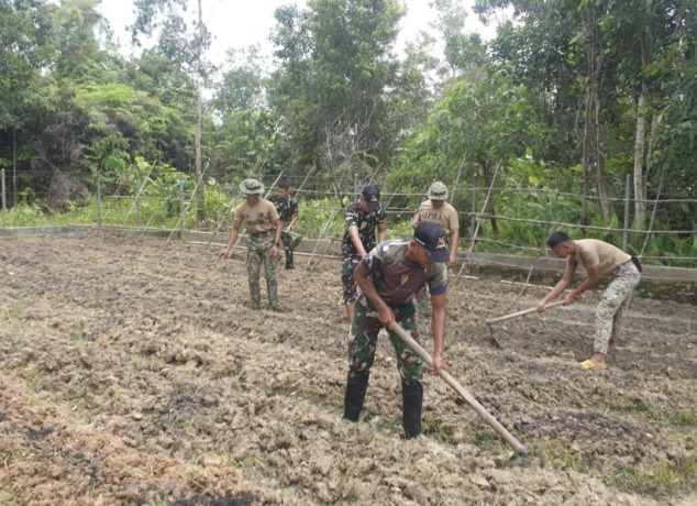 SAYUR: Kedua tentara perbatasan Indonesia dan Malaysia saat melakukan tanam sayur bersama. IST/ FIK/KAPUAS HULU