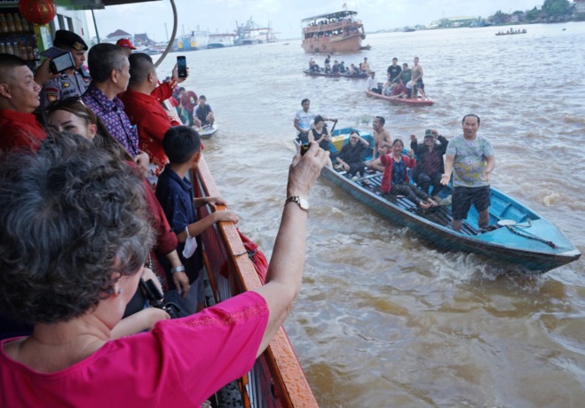 FESTIVAL BAKCANG: Warga membagikan panganan bakcang saat pelaksanaan pawai festival bakcang di Sungai Kapuas, Kamis(22/6). Masyarakat Tionghoa rutin mengelar festival tersebut sebagai bentuk rasa syukur. (HARYADI/PONTIANAK POST)