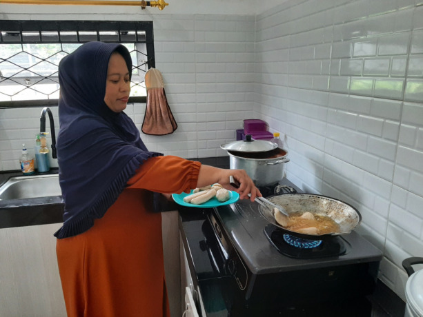 Yuli saat menggoreng pempek Palembang, camilan kebanggan keluarganya. (Syahriani/Pontianak Post)