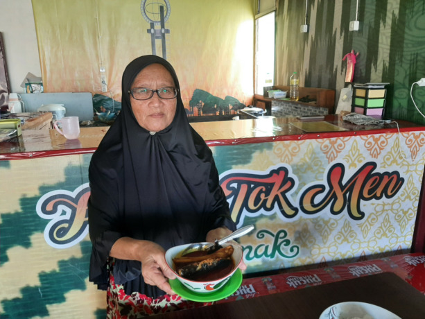 Bu Atik menunjukkan patin asam pedas yang dijual di kedai miliknya. (Syahriani/Pontianak Post)