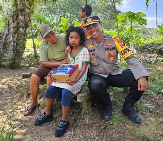 SEPATU BARU: Fika, menerima sepatu baru dari Polsek Rasau Jaya bekerjasama dengan Rumah Zakat Kalbar. IST