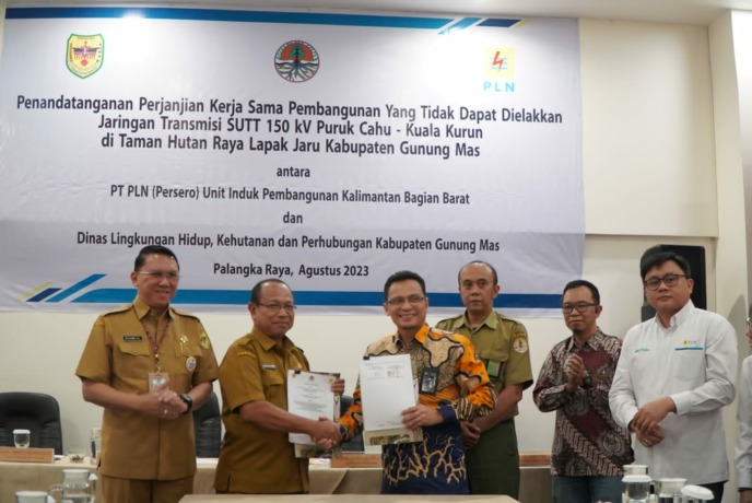 Foto penandatanganan PKS Pembangunan Yang Tidak Dapat Dielakkan Jaringan Transmisi SUTT 150 kV Puruk Cahu - Kuala Kurun Tahura Lapak Jaru Kab. Gunung Mas yang ditandatangani oleh Kepala DLHKP Gunung Mas, Rody Aristo Robinson dan General Manager PLN UIP KL