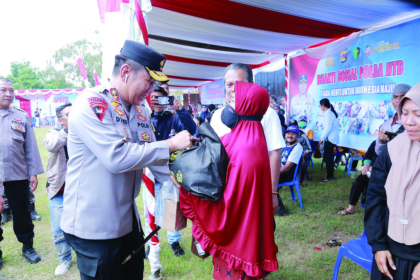 BAKSOS: Kapolda NTB Irjen Pol Djoko Poerwanto memberikan paket sembako kepada salah seorang warga dalam kegiatan baksos menyambut 34 tahun pengabdian Altar 89 di Lapangan Bhara Daksa Polda NTB, Sabtu