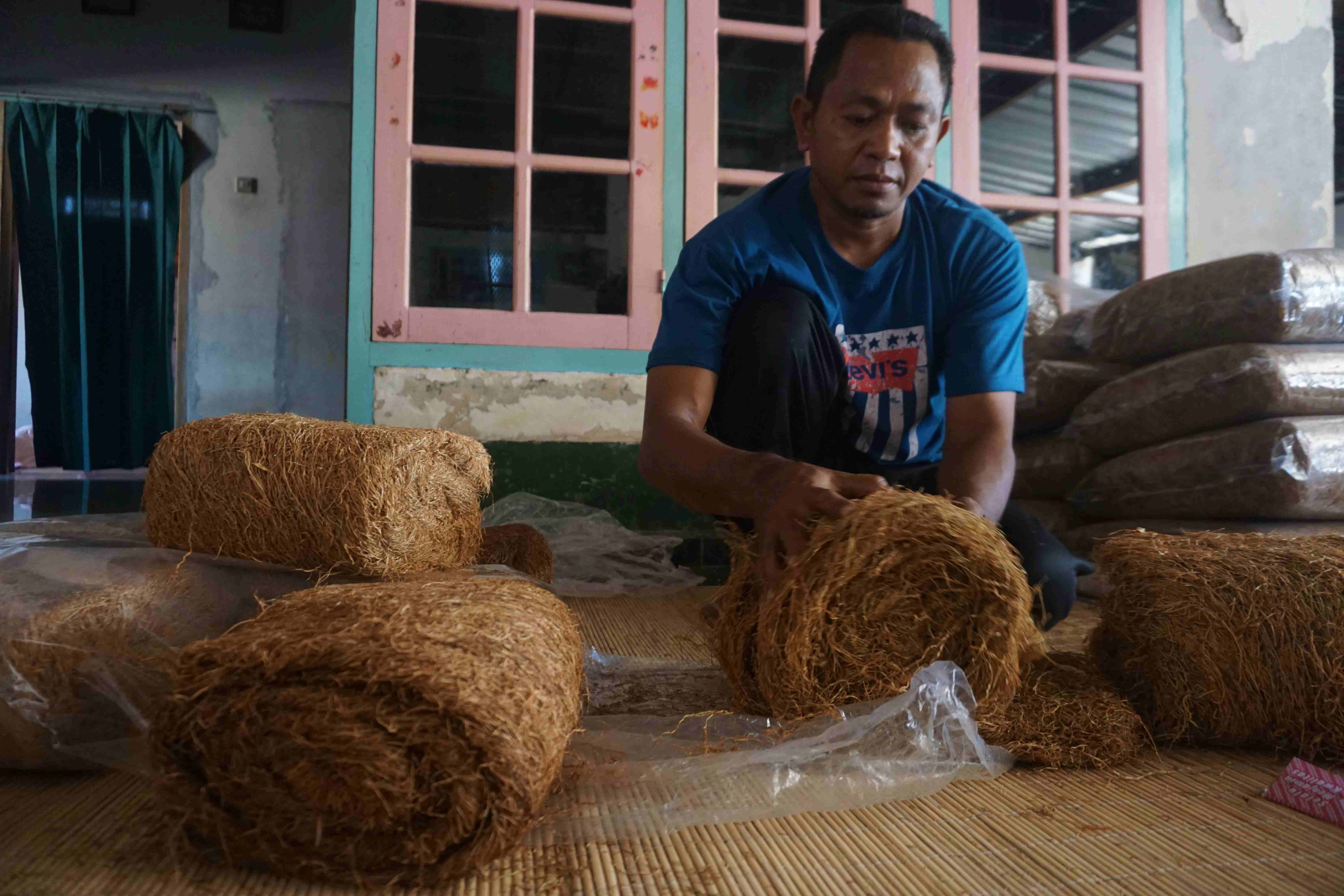 SAUDAGAR TEMBAKAU: Suaidi, petani sekaligus saudagar tembakau rajangan dari Desa Apitaik, Kecamatan Pringgabaya tengah mengemas tembakau rajangan jenis kasturi jepun super miliknya di rumahnya.