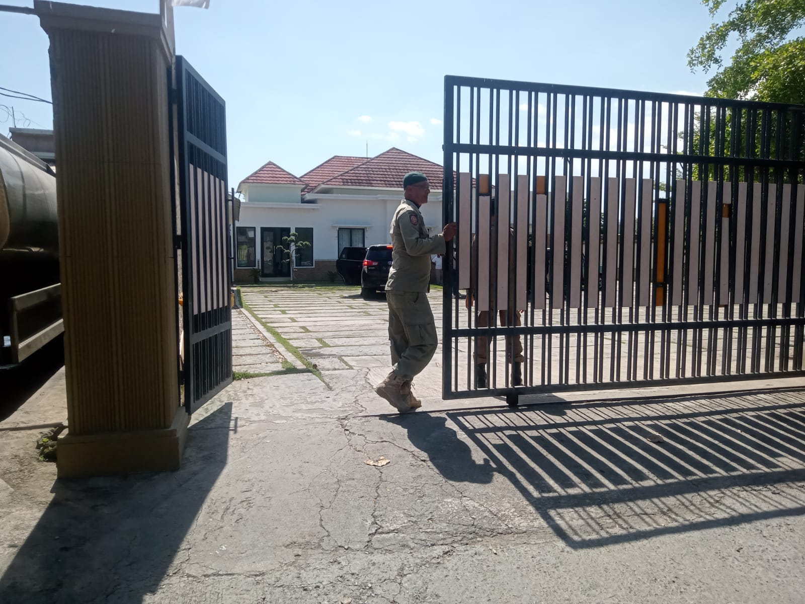 DIGELEDAH: Anggota Satpol PP Kota Bima  berjaga di gerbang  rumah dinas Wali Kota Bima Muhammad Lutfi saat penggeledahan KPK  berlangsung, kemarin (30/8/23).
