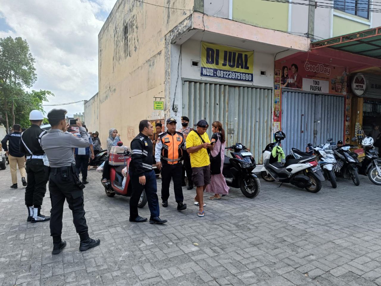 Seorang jukir asyik melihat ponselnya, sementara petugas menarik lengannya masuk ke bus untuk didata di kantor Dinas Perhubungan Kota Mataram.