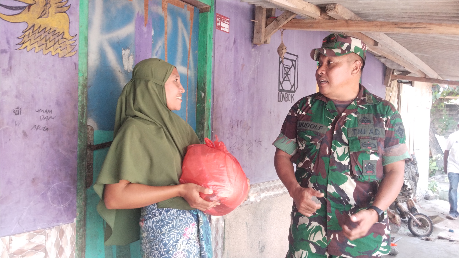 Danramil 1620-04/Praya Barat Kapten Inf. Wage Rudolf S (kanan) menyerahkan bantuan sembako kepada warga nelayan di pesisir Pantai Selong Belanak, Desa Selong Belanak, Kecamatan Praya Barat, Loteng, ke