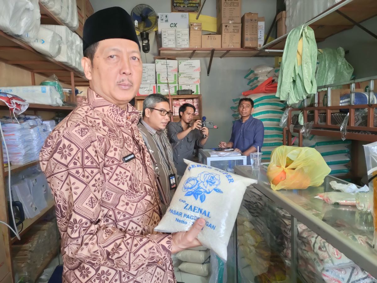 CEK HARGA: Sekda Kota Mataram H Lalu Alwan Basri mengangkat beras pada saat mengecek beras di Pasar Pagesangan, Kota Mataram, Jumat (22/9/23) lalu.