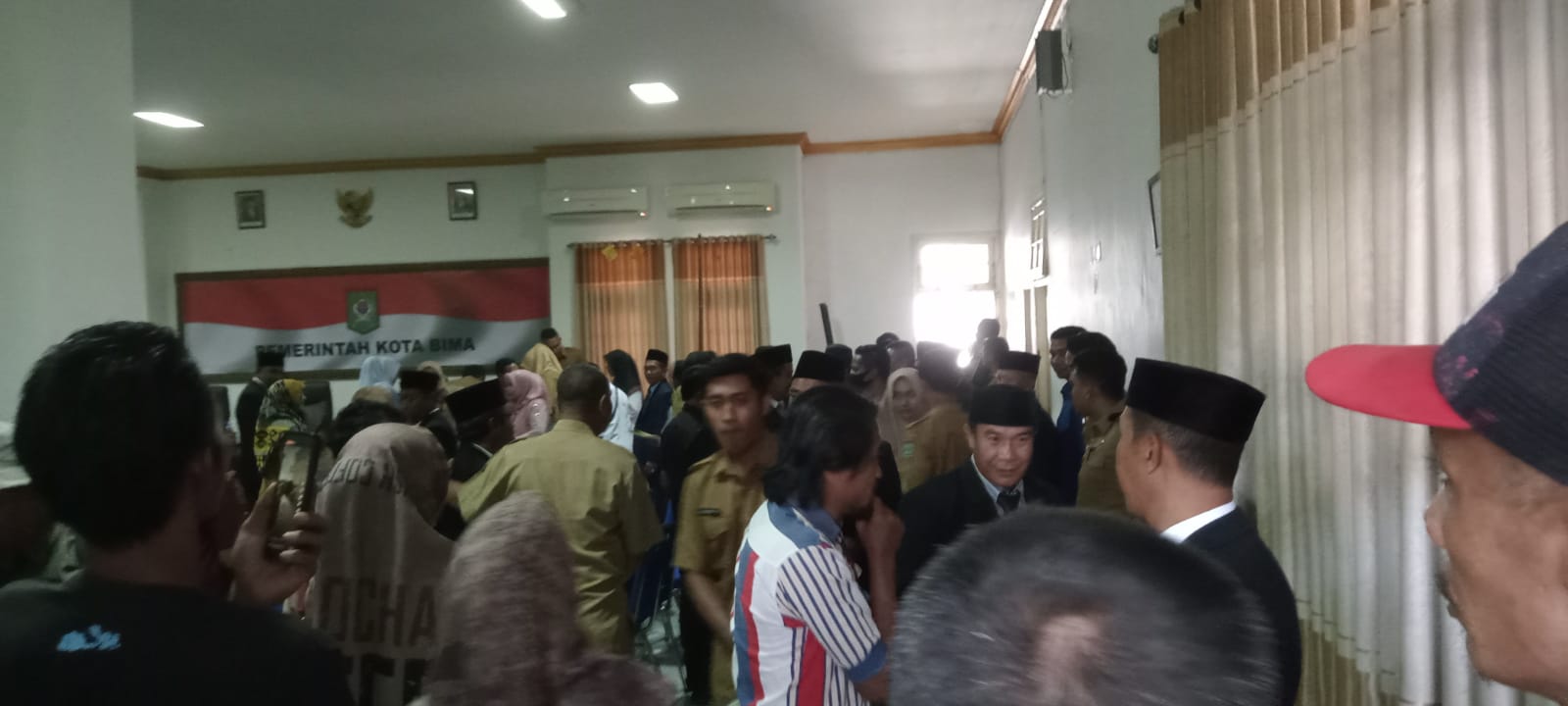 DILARANG MELIPUT: Suasana anggota Satpol PP Kota Bima meminta wartawan keluar dari aula kantor Wali Kota Bima, Senin (25/9)