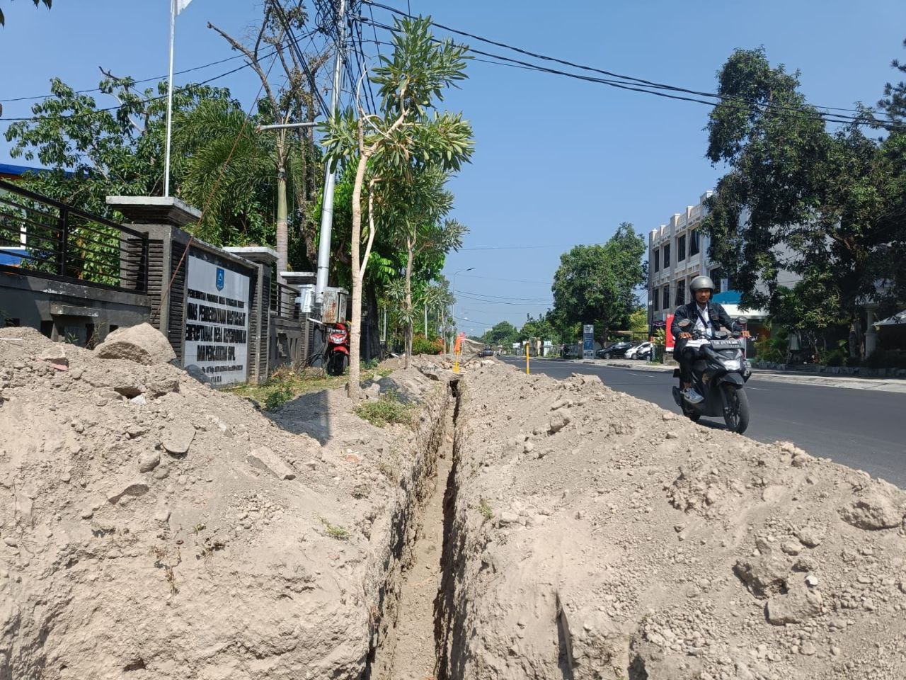 Trotoar jalan yang berlobang oleh proyek PTAM Giri Menang untuk perbaikan pemipaan.