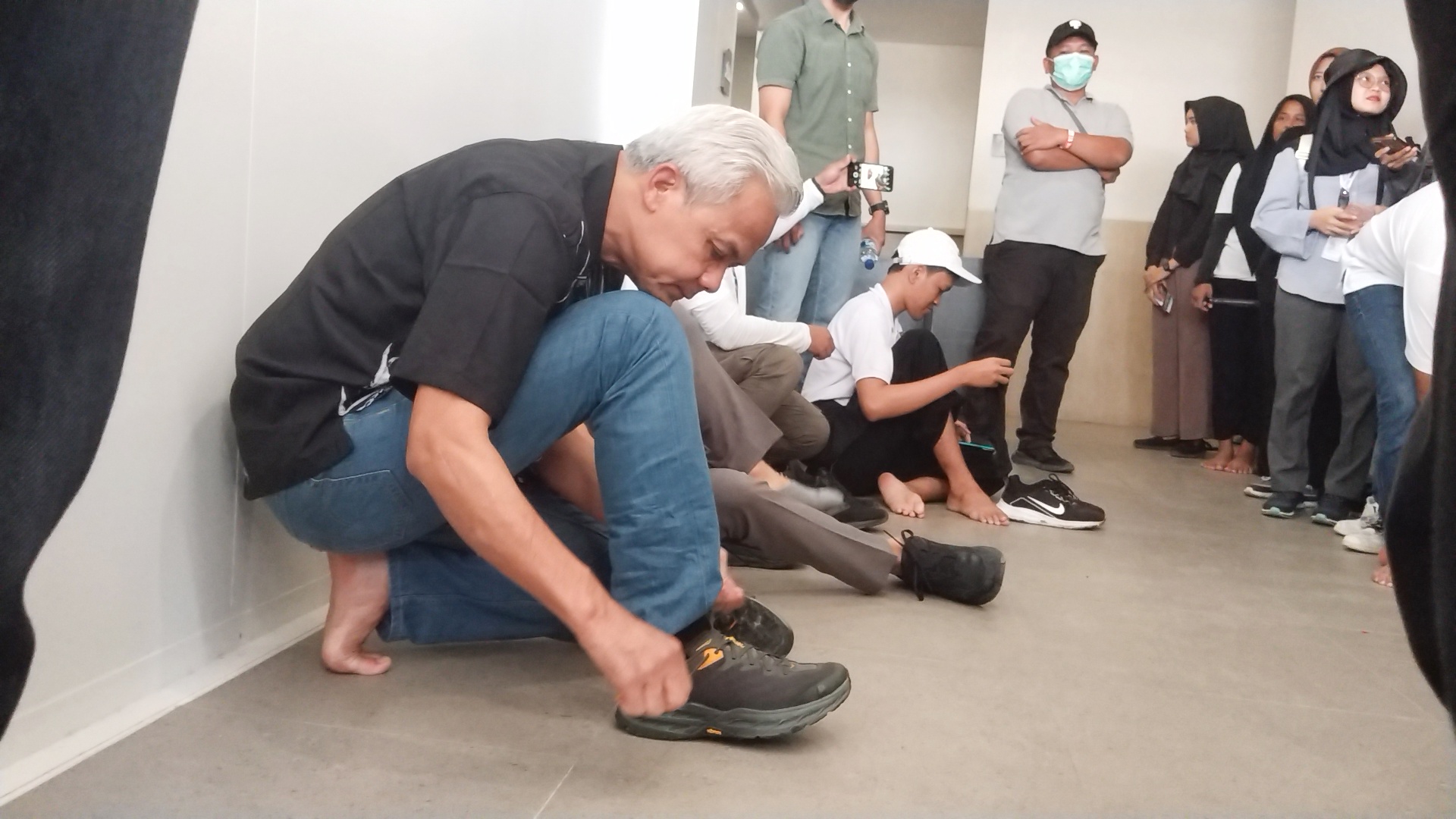 Bakal Calon Presiden 2024 Ganjar Pranowo memasang kembali sepatunya usai solat dzuhur di musholla Deluxe Class, Sirkuit Internasional Pertamina Mandalika, Minggu (15/10) pukul 14.30 Wita.