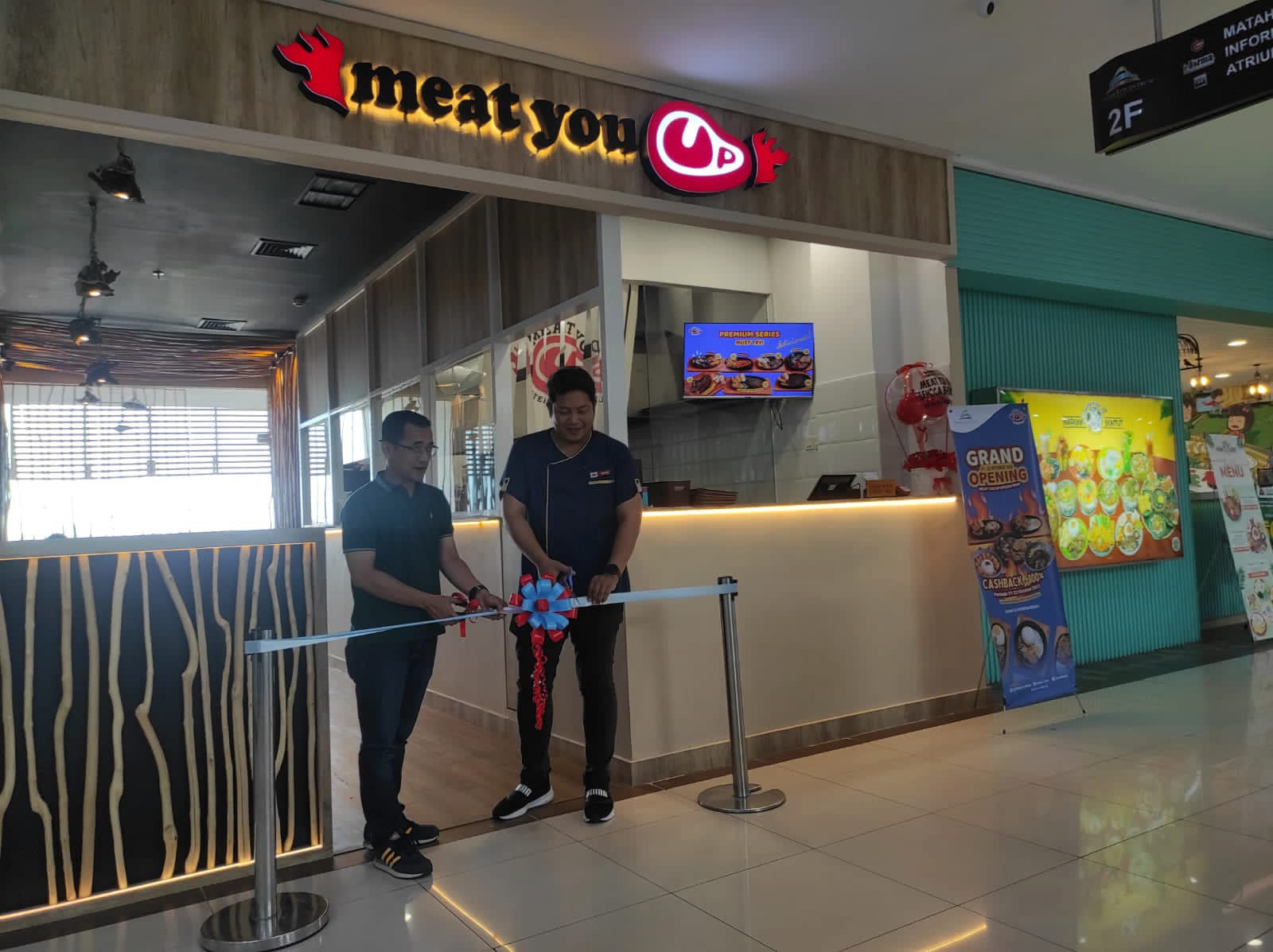 GRAND OPENING: Tenant Coordinator Manager Lombok Epicentrum Mall Dadit Ujayana (kiri) dan Owner tenan Meat You Up Dimas melakukan pemotongan pita grand opening.