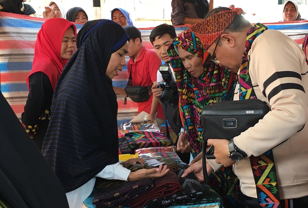 BELI TENUN BIMA: Pj Gubernur NTB H Lalu Gita Ariadi (kanan) saat membeli kain tenun Renda dari salah satu IKM di Sentra IKM Tenun Desa Renda Kecamatan Belo, Kabupaten Bima, Minggu (22/10)