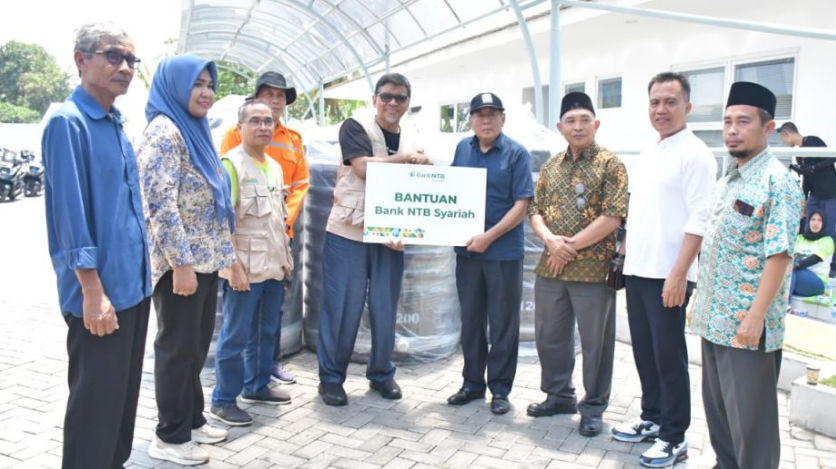 DATANG MEMBANTU: Direktur Utama Bank NTB Syariah H Kukuh Rahardjo (lima dari kanan) menyerahkan secara simbolis bantuan ke Bupati Lombok Utara H Djohan Sjamsu (empat d