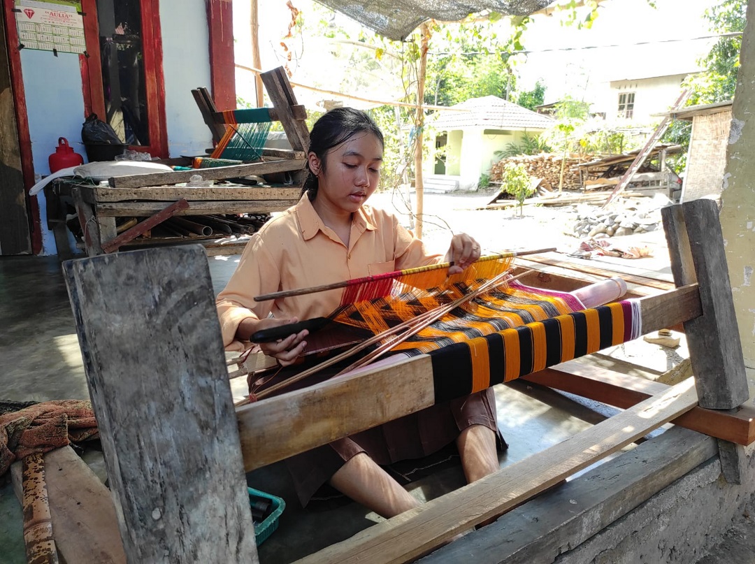 MENENUN: Salah seorang remaja Desa Bayan yang tengah membuat kain tenun Bayan, belum lama ini.(FERIAL/LOMBOK POST)