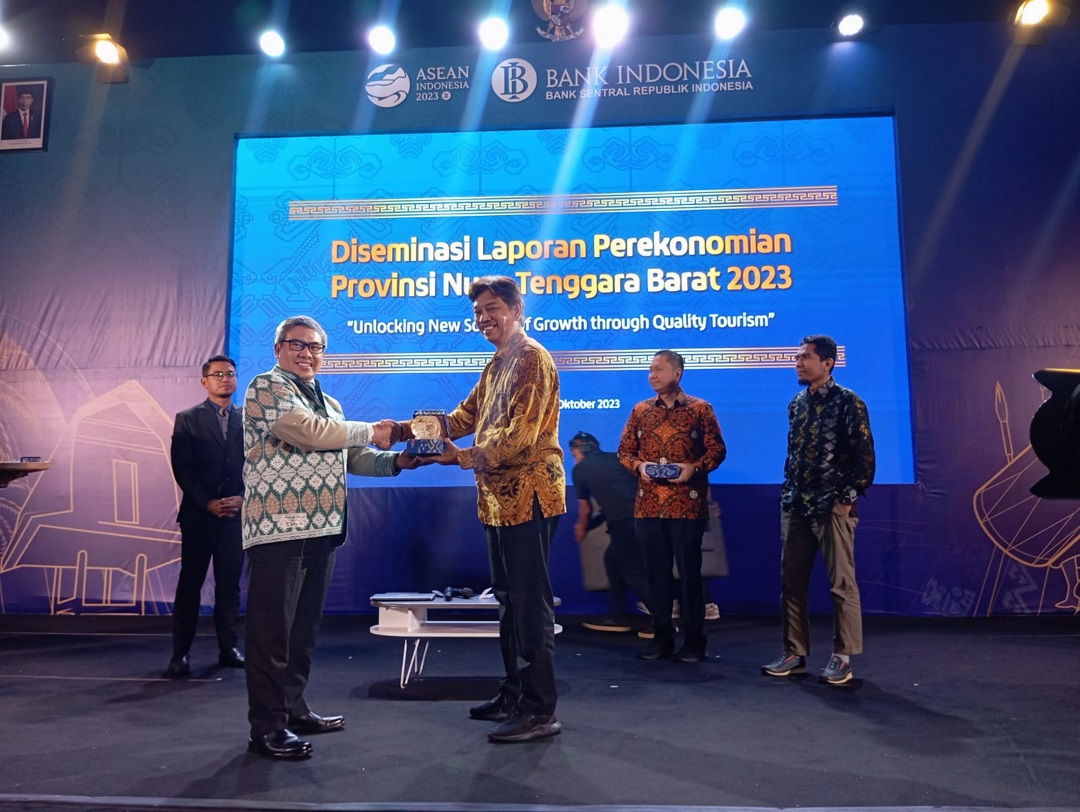 PENYERAHAN PLAKAT: Deputi Kepala Bank Indonesia Perwakilan NTB Ahmad Fauzi (kiri) menyerahkan plakat pada Founder Indecon Ari Suhandi.( FERIAL/LOMBOK POST)