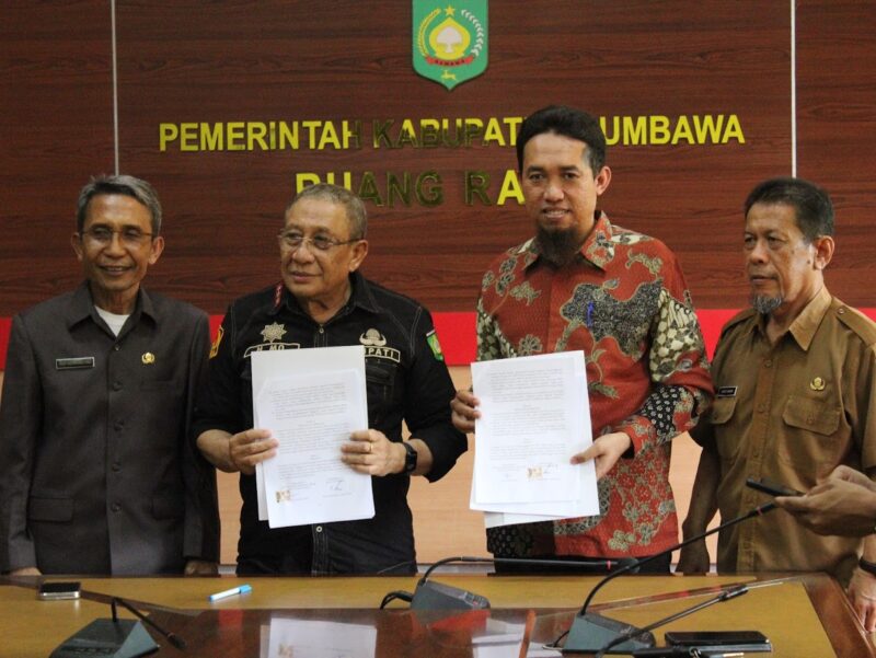 TANDA TANGANI NPHD: Bupati Sumbawa Mahmud Abdullah dan Ketua KPU Sumbawa M Wildan menunjukkan NPHD yang telah ditandatangani. (ABET/LOMBOK POST)