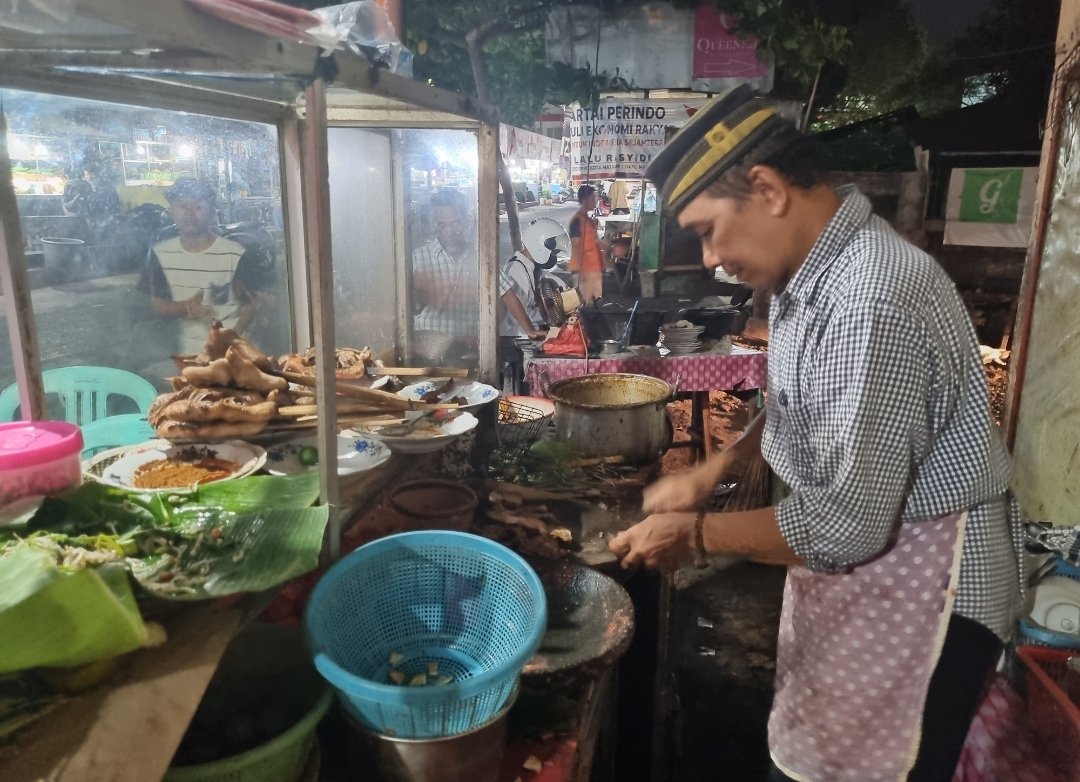 Pak Udin pemilik Kedai Taliwang Pak Udin sedang sibuk mengulek sambal