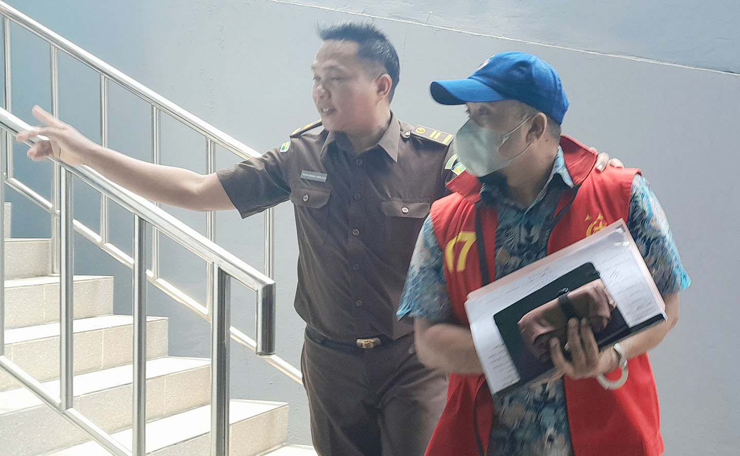Mantan Kabid Minerba Dinas ESDM NTB Trisman (pakai topi) dikawal jaksa untuk menjalani penahanan, Senin (30/10).