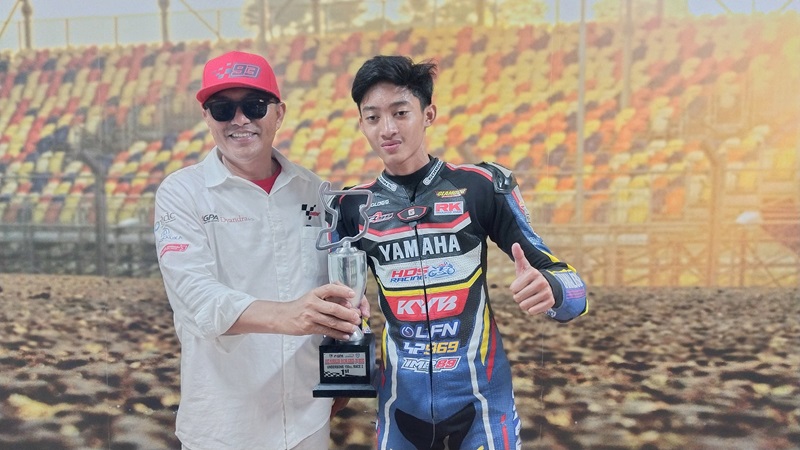 LOCAL HERO: Kepala Dispar NTB Jamaluddin Malady (kiri) berfoto bersama Arai Agaska juara Mandalika Racing Series kelas Underbond 150 CC di Sirkuit Internasional Pertamina Mandalika, Minggu (29/10)