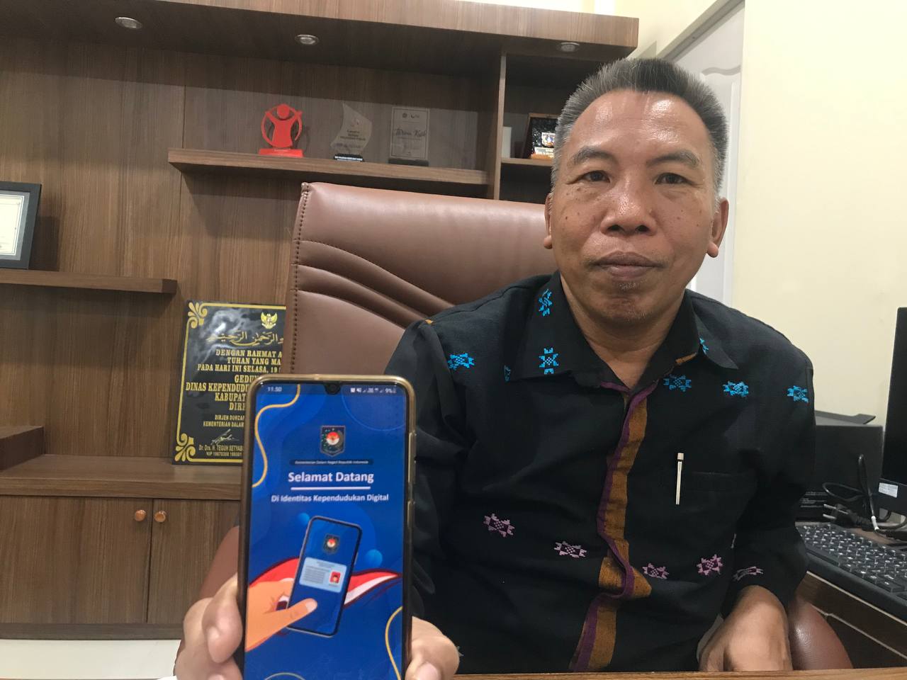 APLIKASI KEPENDUDUKAN: Kepala Dinas Dukcapil Lombok Utara H Rubain menunjukkan aplikasi identitas kependudukan digital di kantornya, Selasa (31/10).(NURUL/LOMBOK POST)