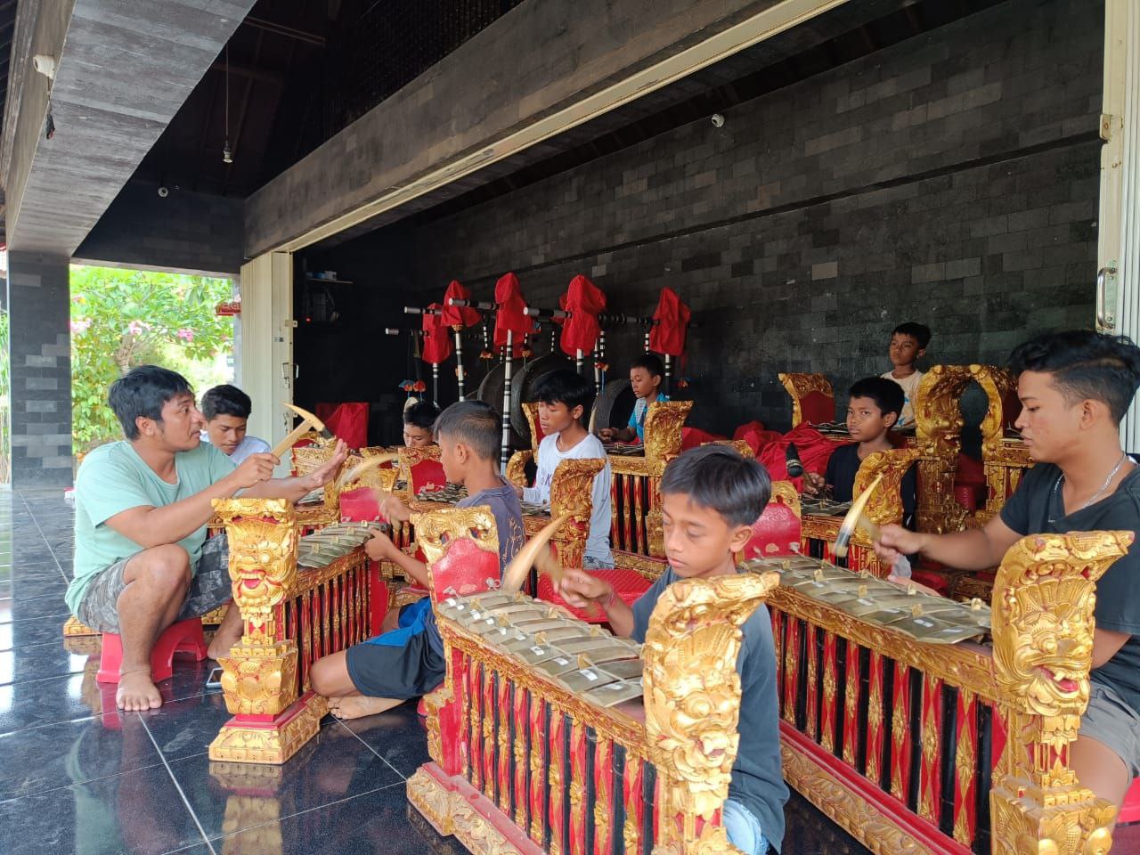 Ida Bagus Natha Surriyatanaya (baju hijau) saat mengajari anak-anak Sindu Barat bermain gamelan.