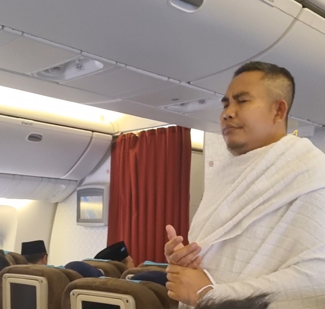 Ustad Ari Suhaimi saat membing jemaah umroh kafilah ke 3 Bank NTB Syariah bersama Muhsinin Tour&Travel di atas pesawat.
